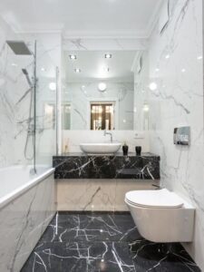 Luxurious bathroom featuring marble walls and floor with modern fixtures and minimalist design. Done by a tile contractor