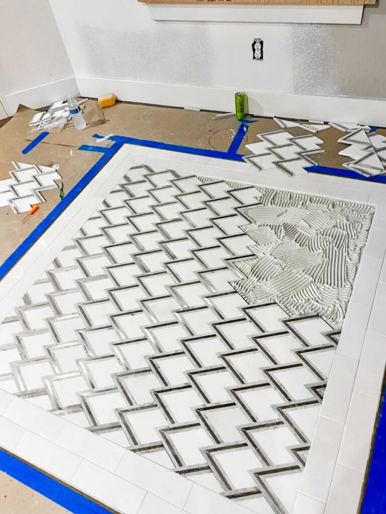 photo_24_2025-03-01_20-04-21 Geometric tile installation in progress with a modern zigzag pattern.