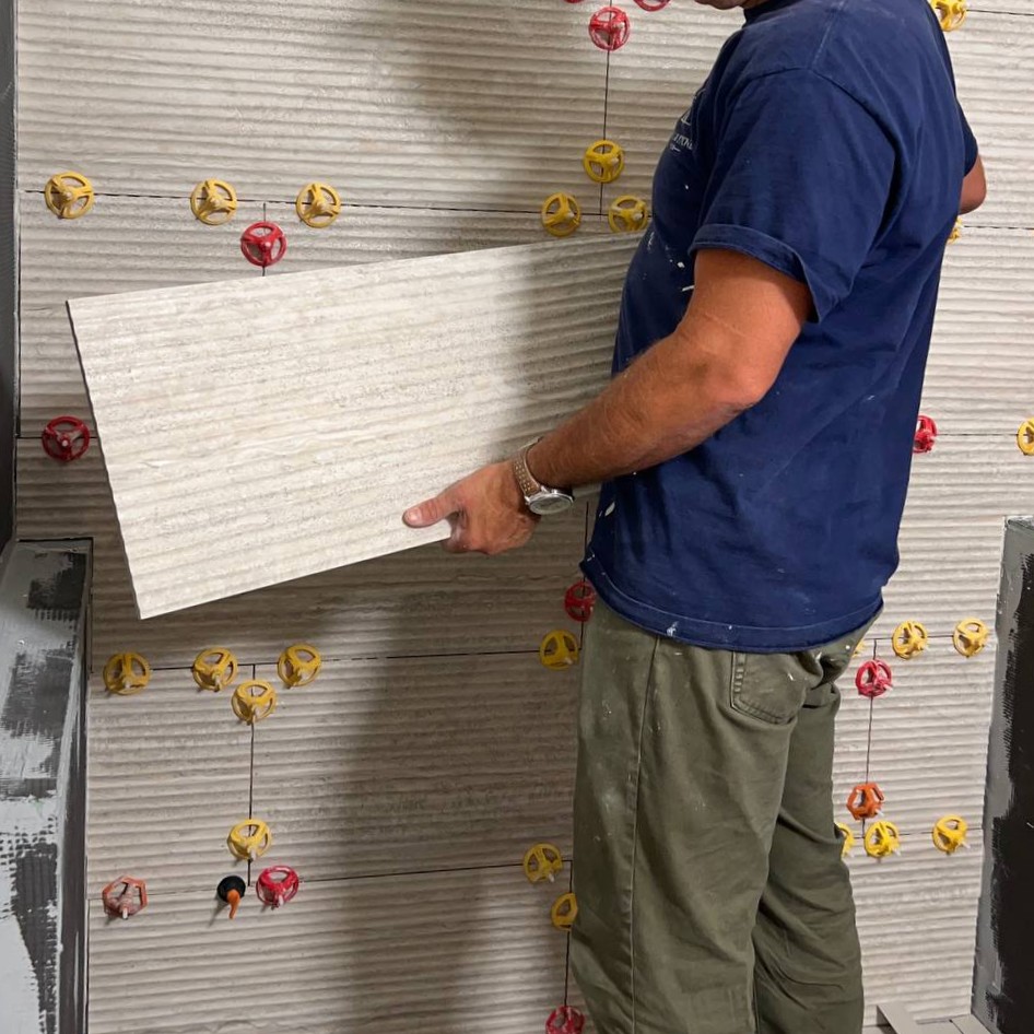 Andzhei setting large textured wall tile in a shower — Ability Tiles, Greater Seattle