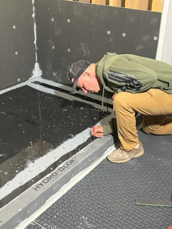 Andzhei finishing a shower curb before tile