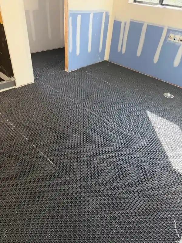 Bathroom floor covered with Ditra uncoupling membrane before tile