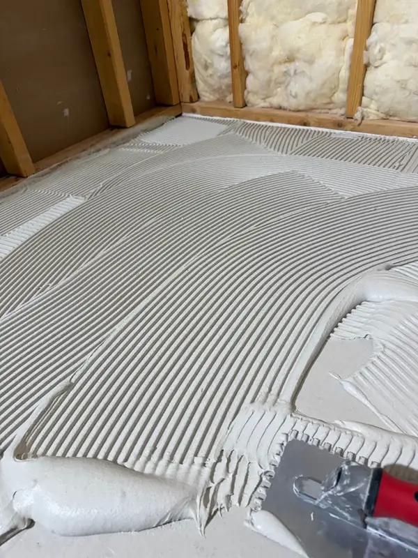 Close-up of notched trowel thin-set ridges on shower floor