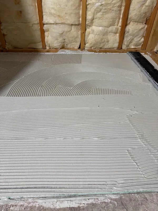 Shower floor thin-set mortar combed before pan or tile