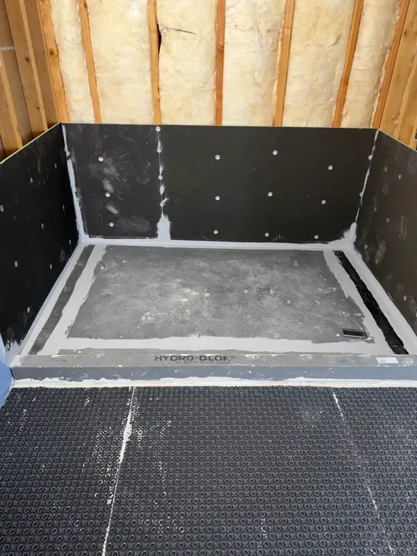 Walk-in shower walls, pan, and curb ready for tile